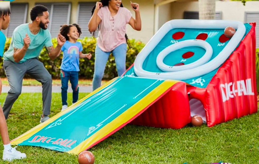 family playing with inflatable skee ball game outdoors