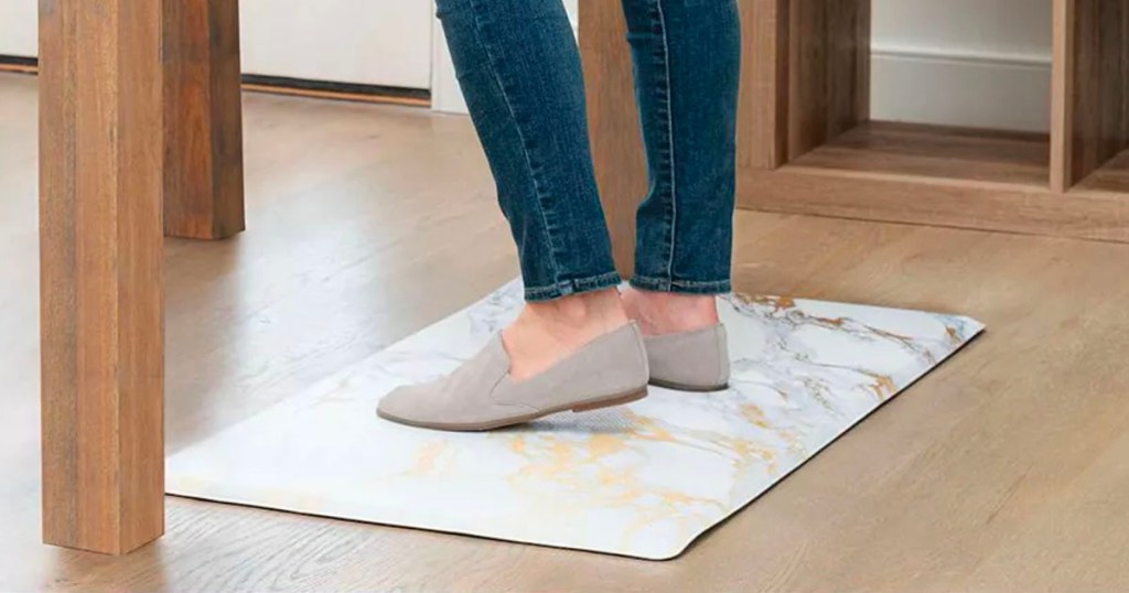 woman standing on white, gray and gold marble kitchen mat