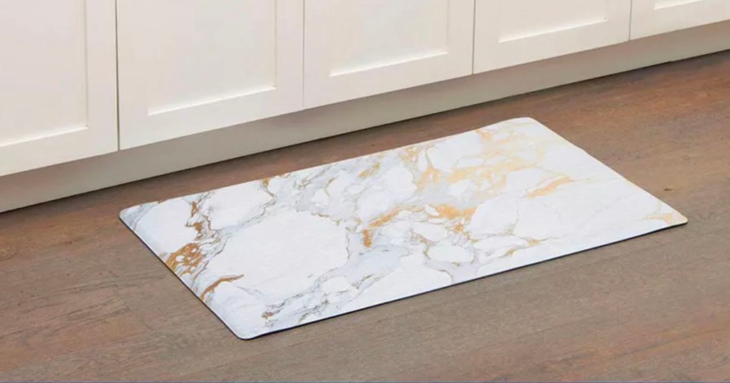 white gray and gold marble ktichen mat on floor next to white cabinets