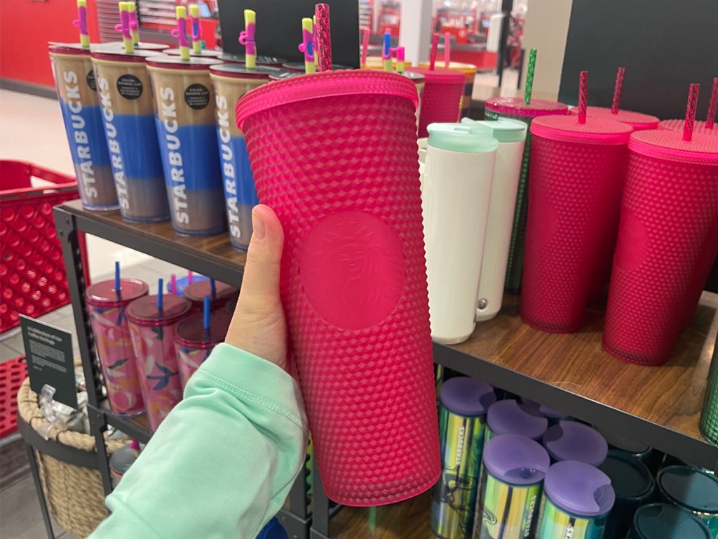 hand holding pink tumbler with studs