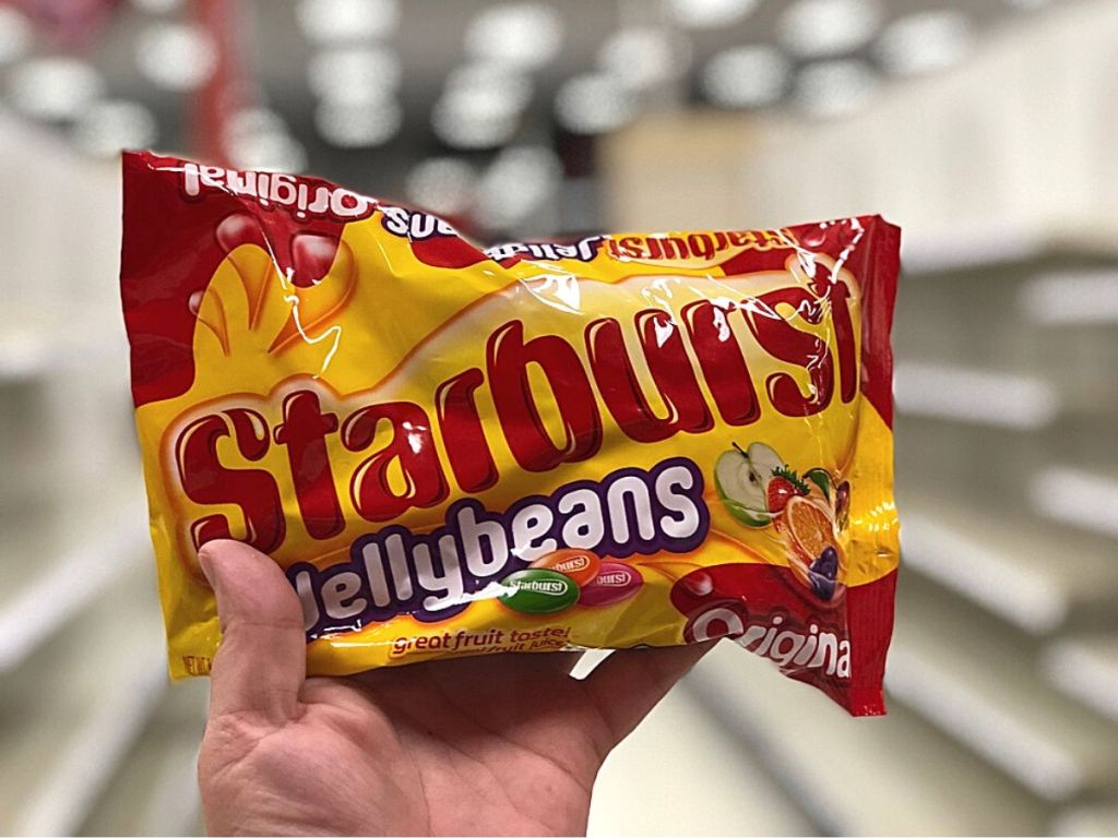 hand holding bag of Starburst Jellybeans in store