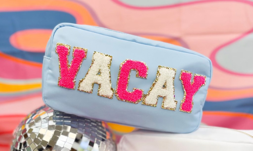 light blue vacay cosmetic bag with colorful background on disco ball