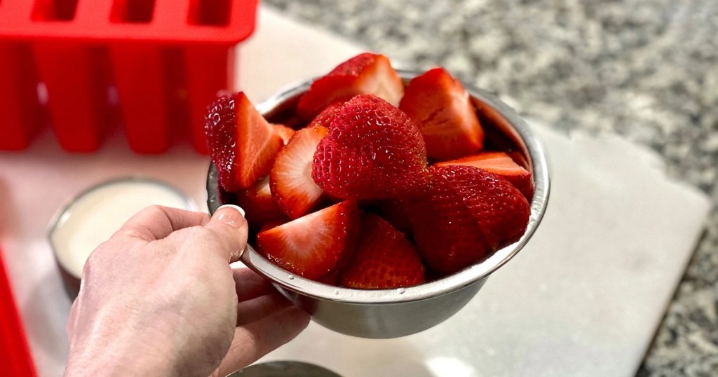 holding a bowl full of strawberries