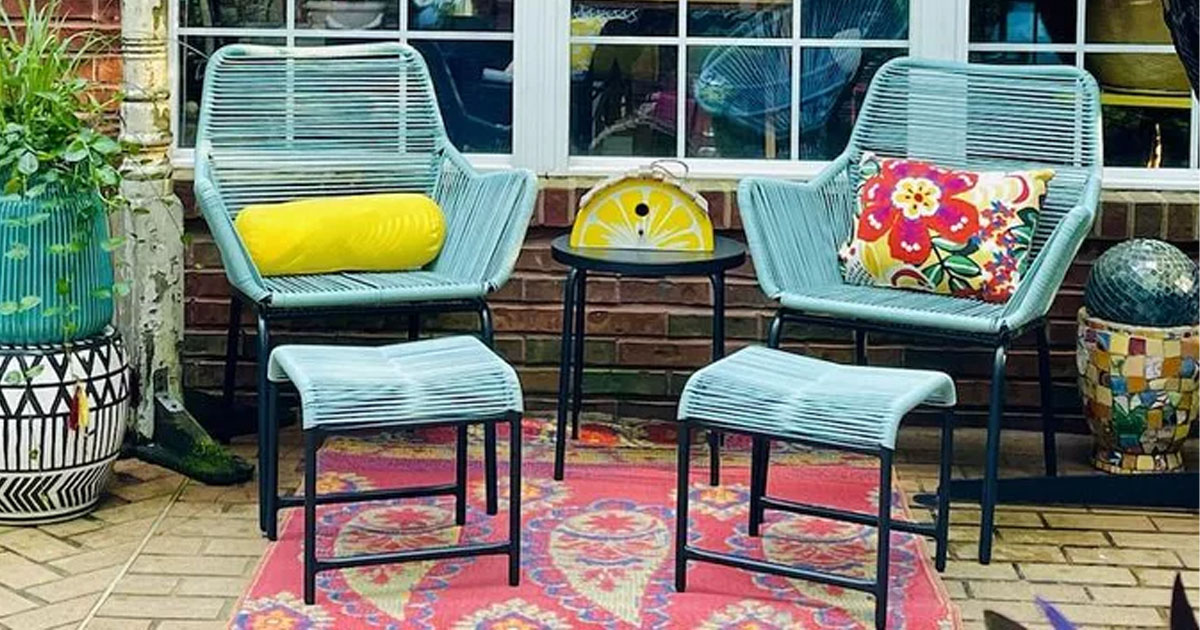 teal patio chair, stool and table set on porch with yellow and flower pillows