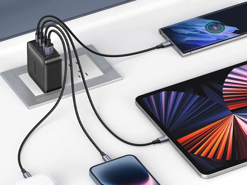 four devices plugged into charger on table