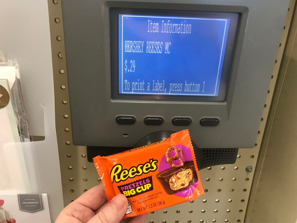hand holding reese peanut butter cup next to price checker