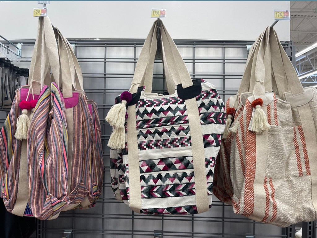 three beach bags hanging in store 