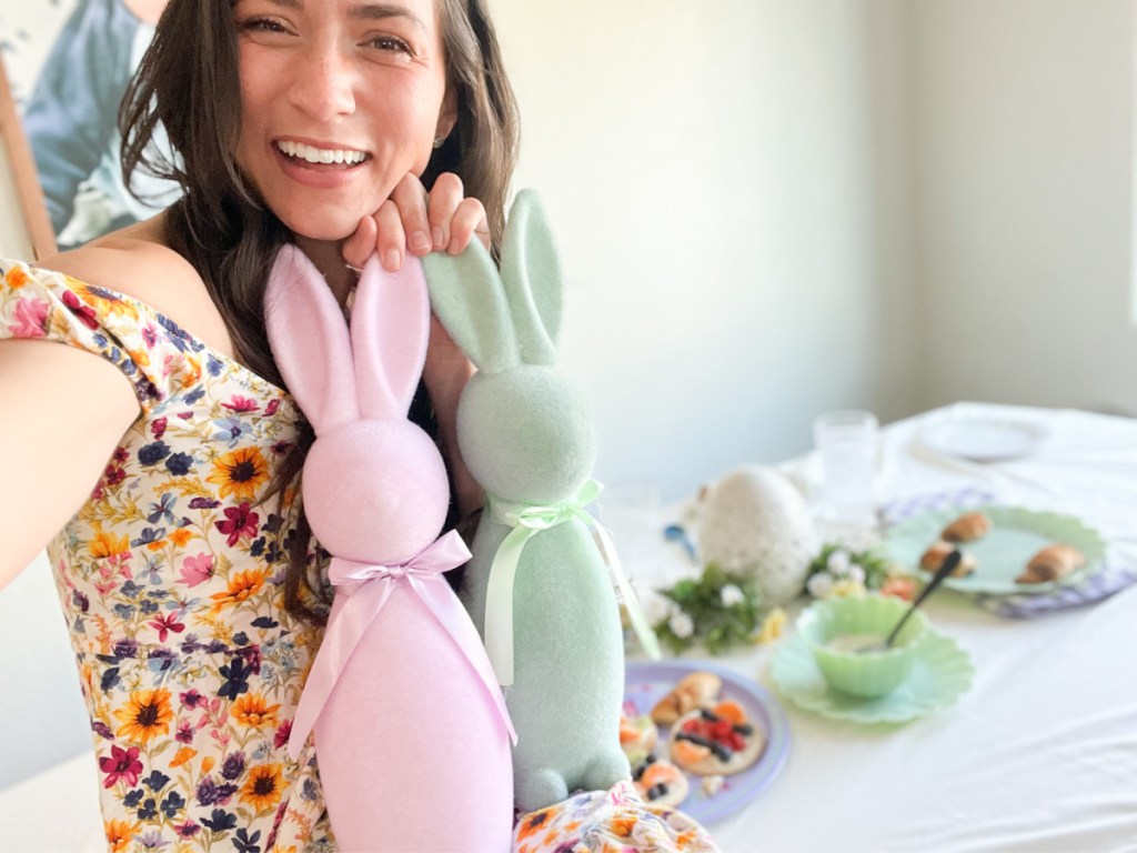 woman holding pink and green bunny decor
