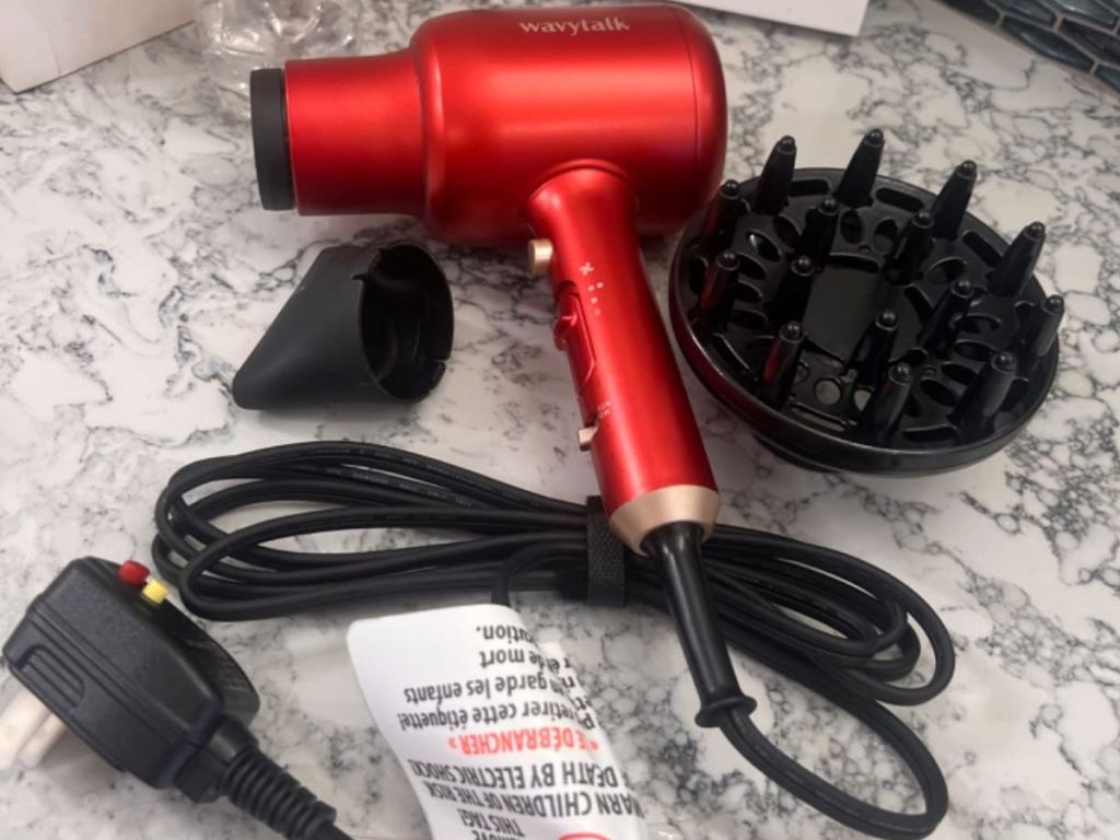 wavytalk blow dryer in red set on counter with two attachments