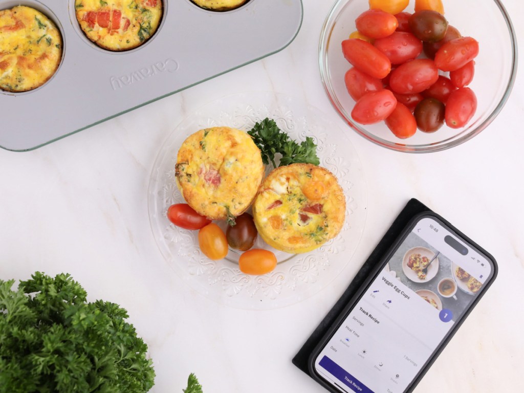 weight watchers egg muffins, tomatoes in a bowl and a smartphone