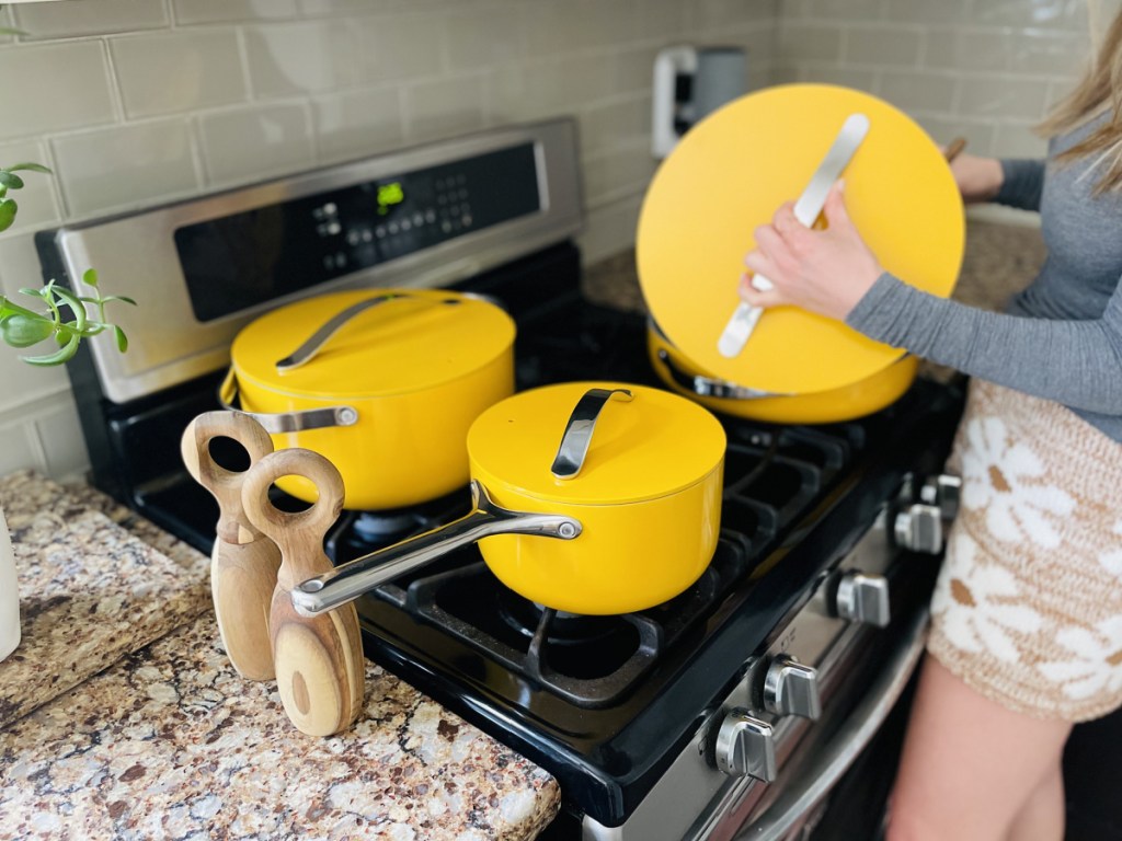 woman cooking in her kitchen with caraway pans on the stove