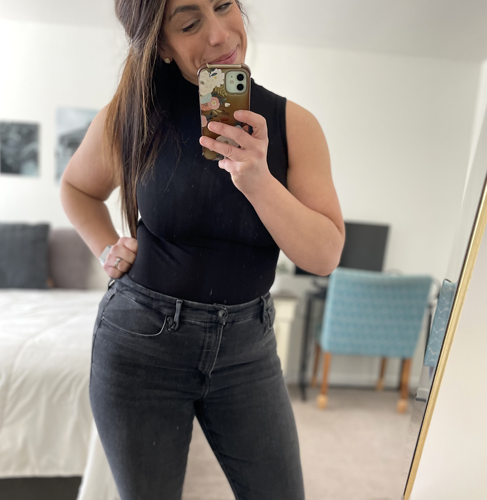 woman wearing black bodysuit and jeans 