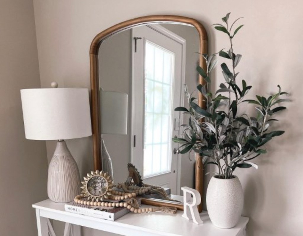 wooden arch mirror on console table with studio mcgee decor