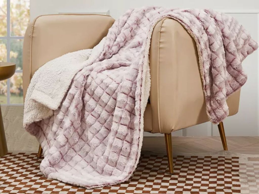 pink throw blanket draped over arm of chair