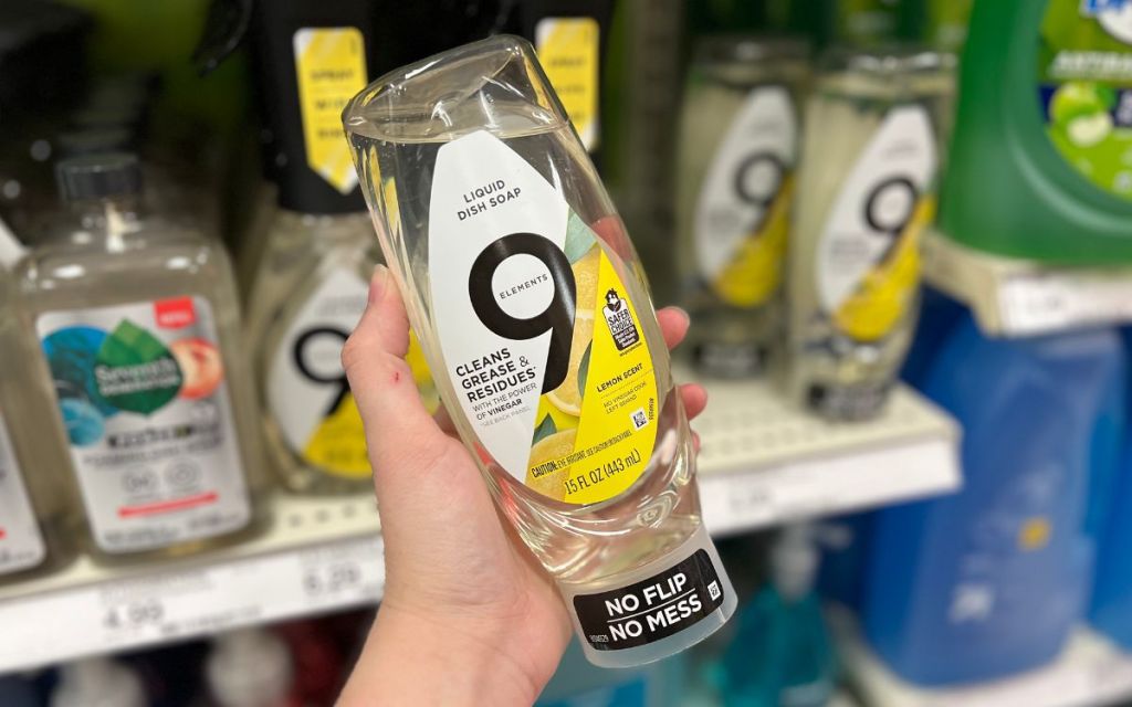a woman's hand holding a bottle of 9 elements ez squeeze dish care
