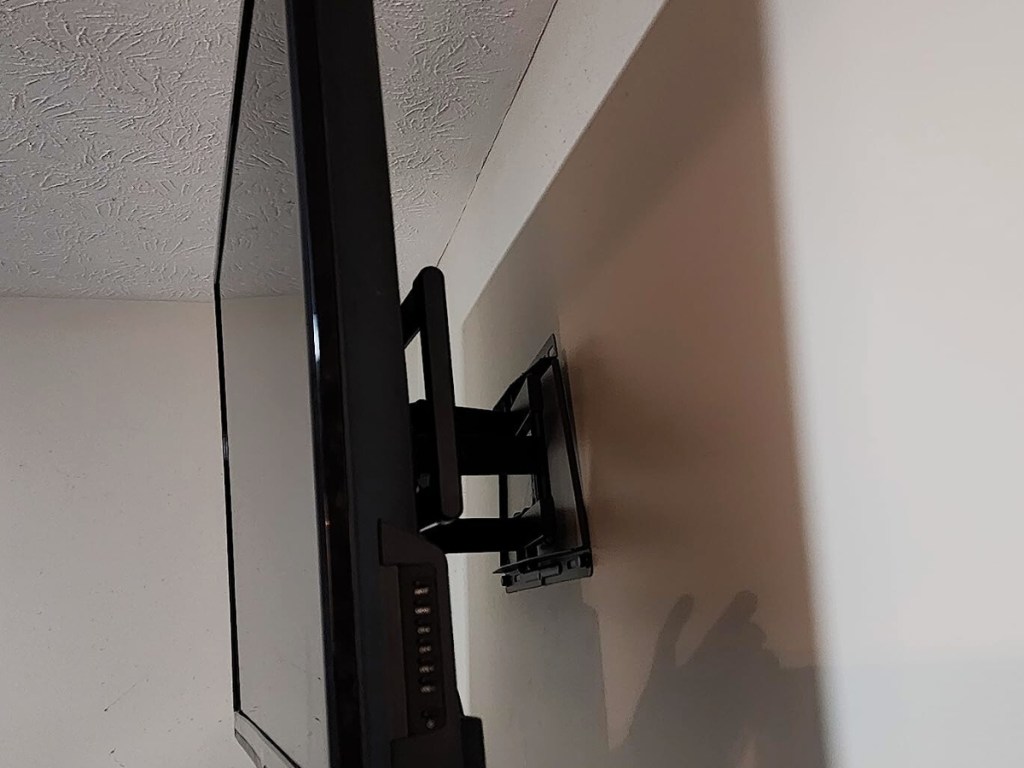 A tv mounted on the wall using a Pipishell Full Motion Wall Mount