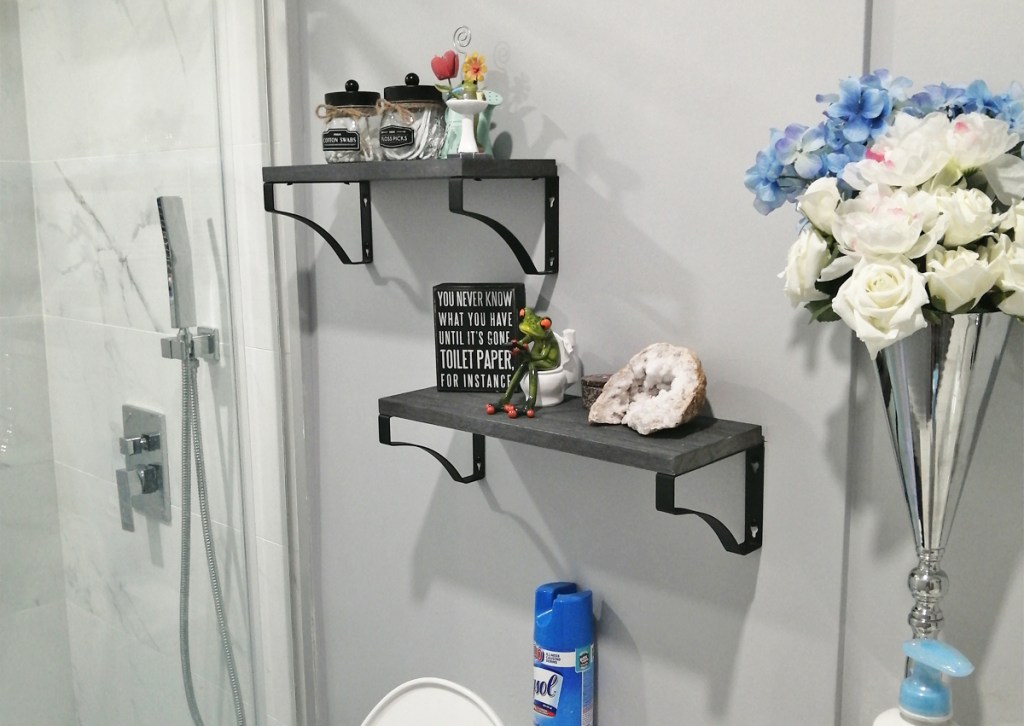 two grey floating shelves in bathroom