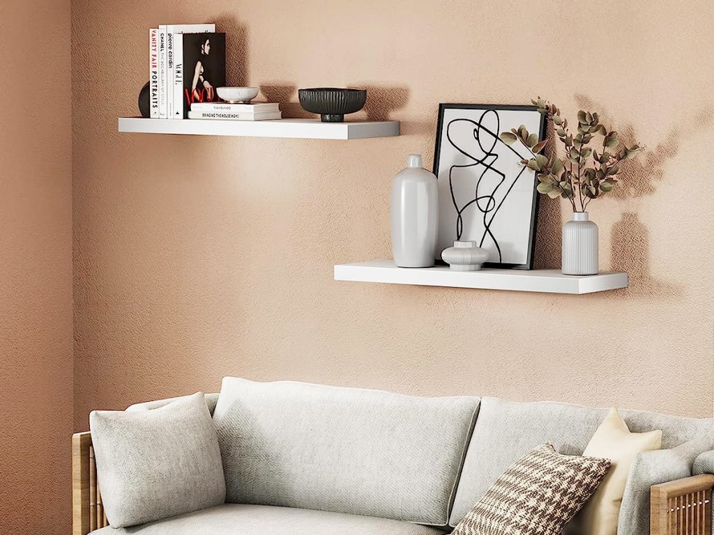 decor on two white floating shelves above couch