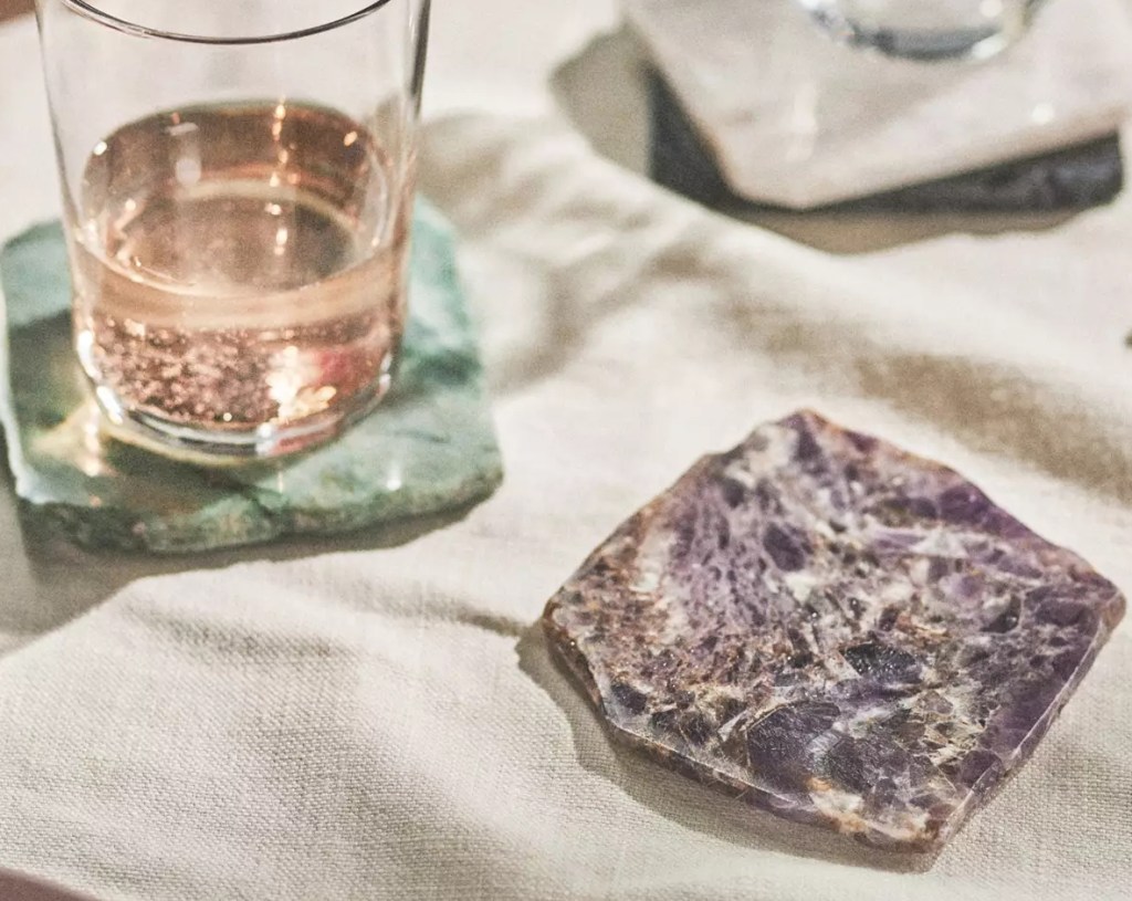 Glass on a blue agate coaster and a purple one sitting next to it