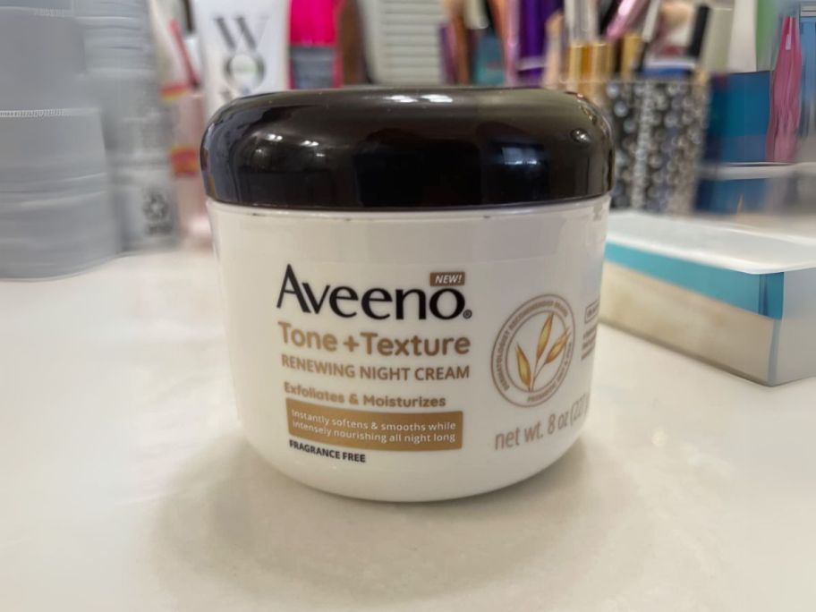 Aveeno Tone + Texture Renewing Body 8oz Night Cream on counter