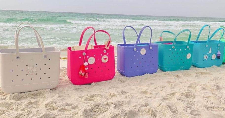 five Baby Bogg Bags set on the sand at the beach in a line