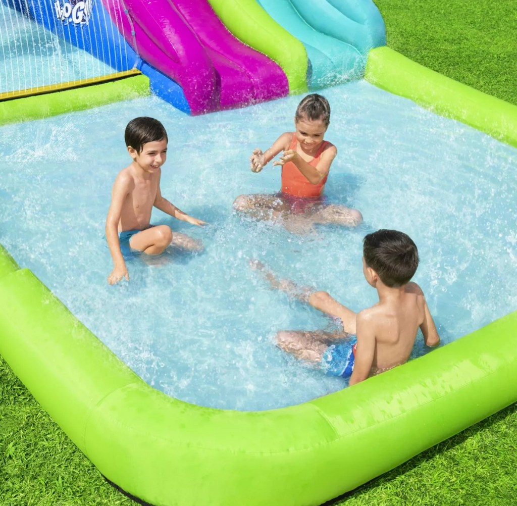 Kids sitting in an inflatable water park pool