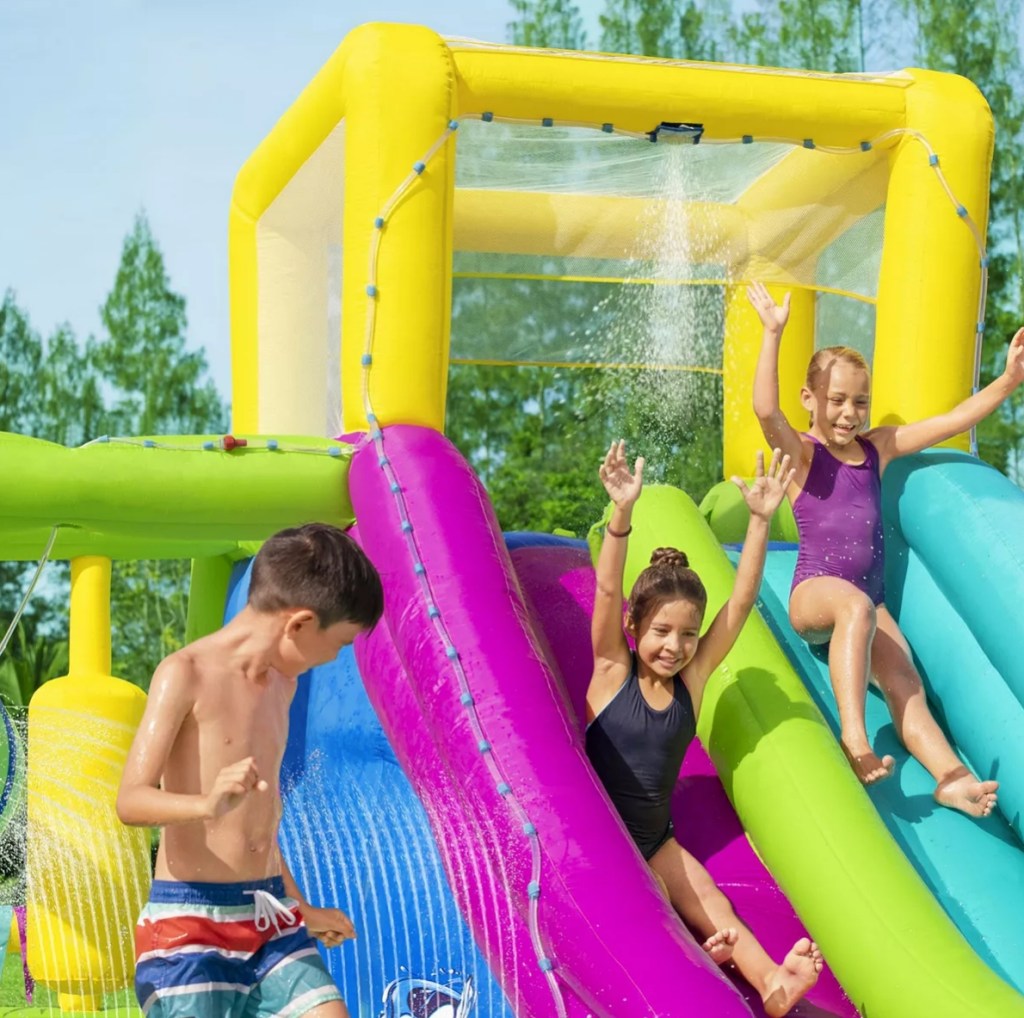 Kids playing on an inflatable water park