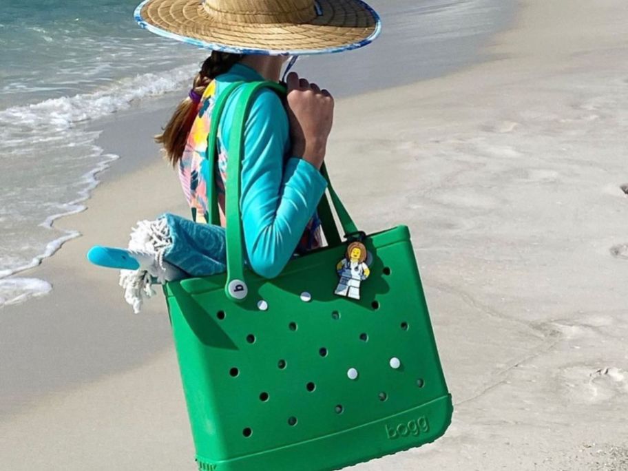 Woman carrying a baby bogg bag at the beach