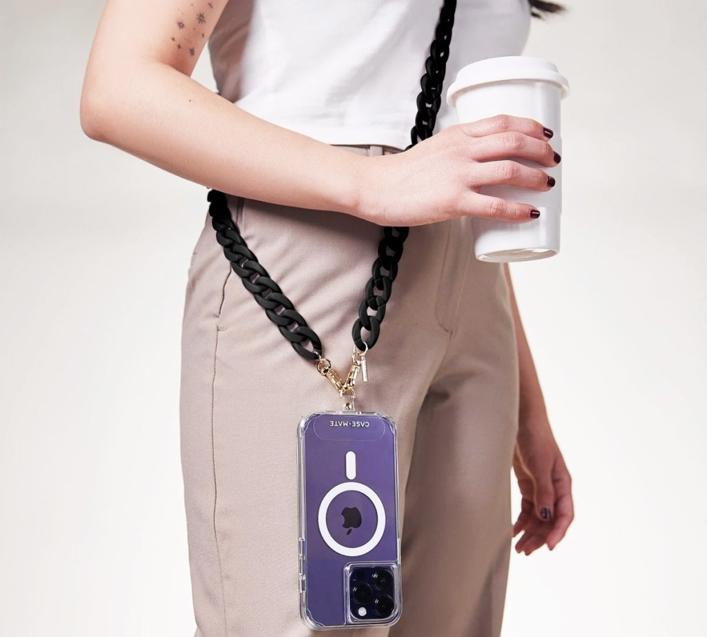 woman with iphone hanging from a crossbody chain