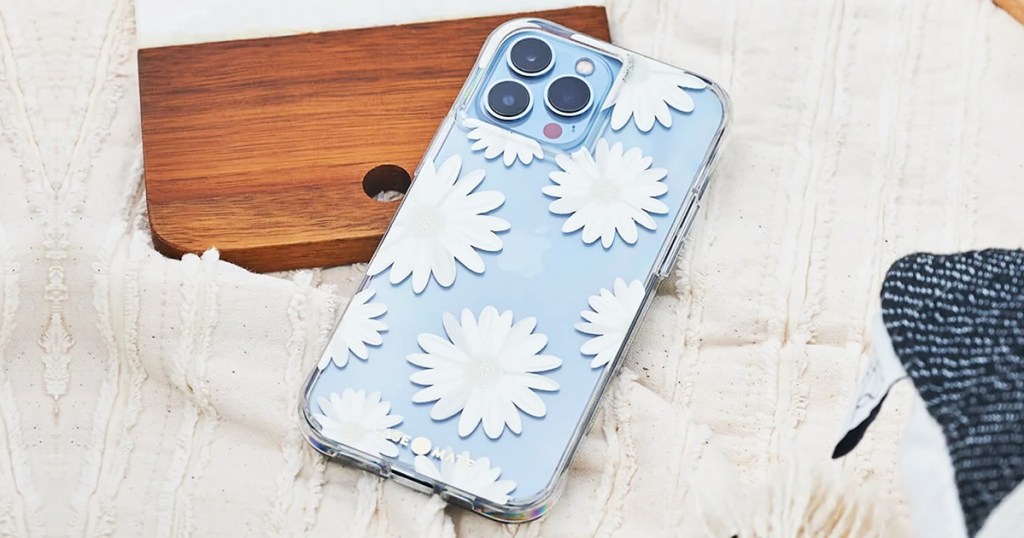 white daisy print phone case on a blue iphone