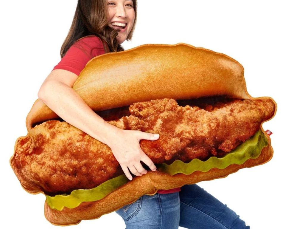 A woman carrying a huge Chick Fil A Sandwich Pillow