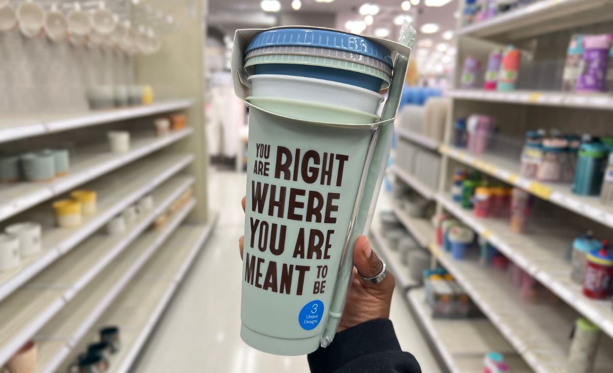 a womans hand holding a bundle of Cold cups in a target store