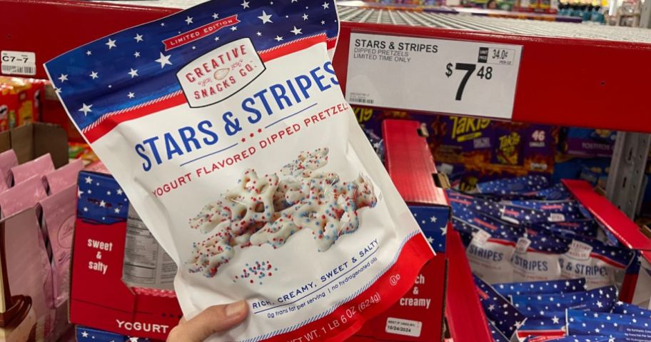 A hand holding a Stars & Stripes Yogurt Dipped Pretzels 22oz Bag 