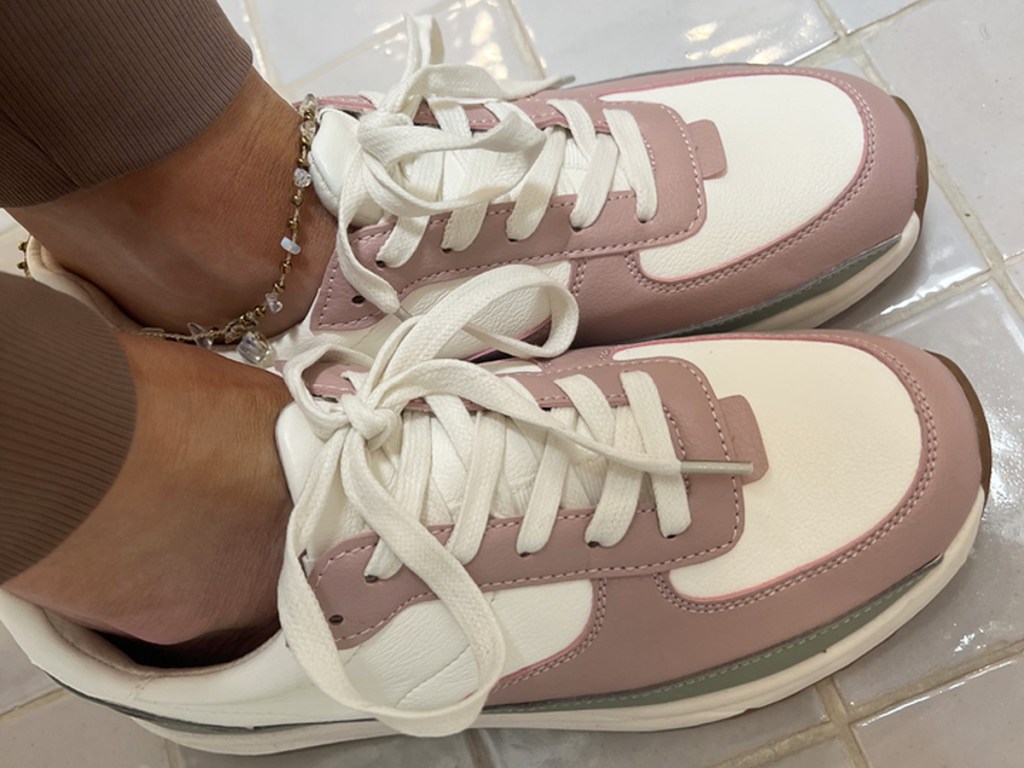 woman wearing a pair of pink and white sneakers