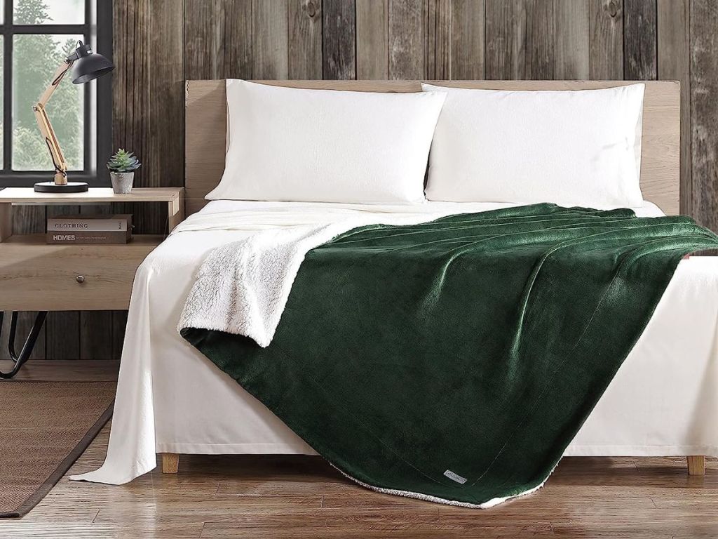 green eddie bauer blanket draped over the bottom of a bed