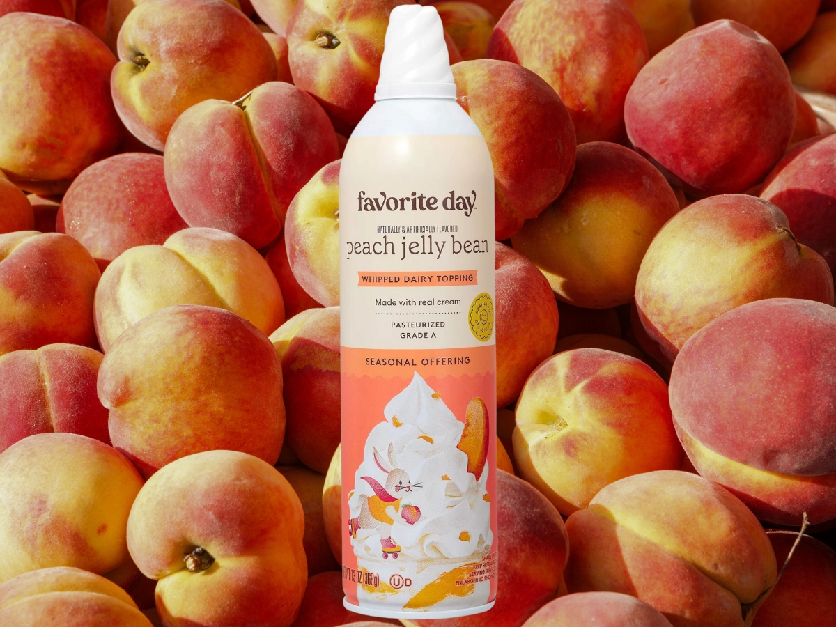 Favorite Day Peach Jelly Bean Whipped Dairy Topping 13oz Can in front of peaches