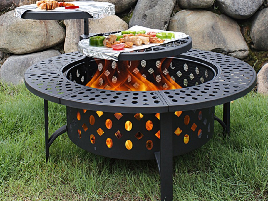 Fire pit with cooking doom on top displayed on the grass