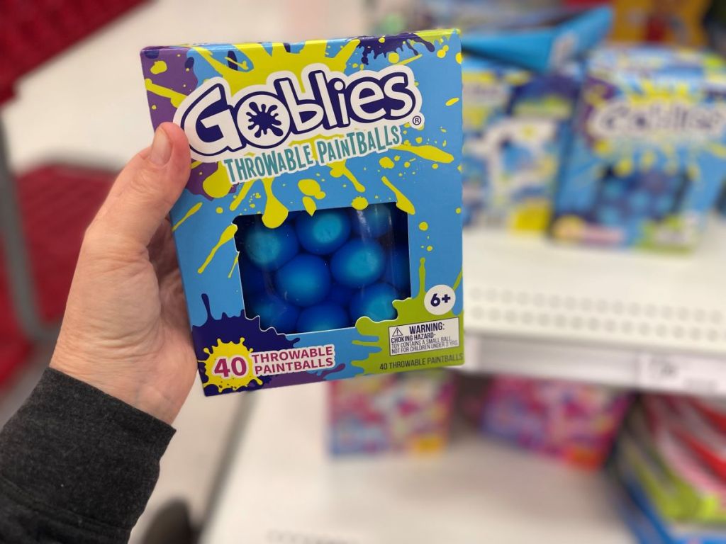 Hand holding a package of Goblies Throwable Paintballs