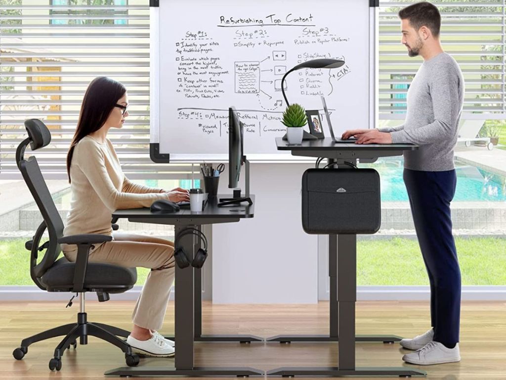 two people using Happyard Standing Desks with one sitting and one standing