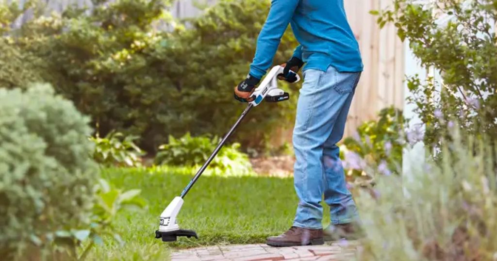 Hart 20-Volt Electric 10 String Trimmer being used by a man in his yard
