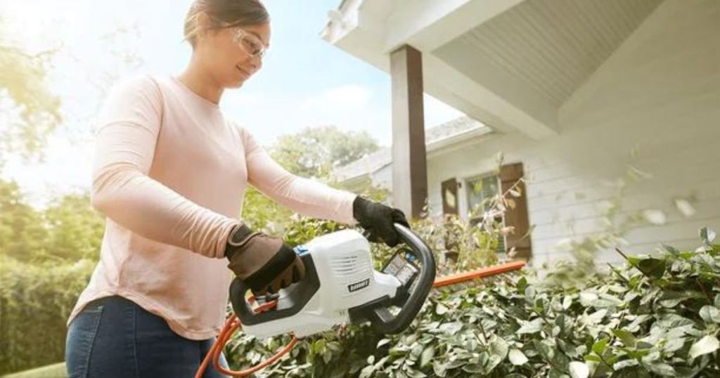 woman using Hart Hedge Trimmer to trim hedges