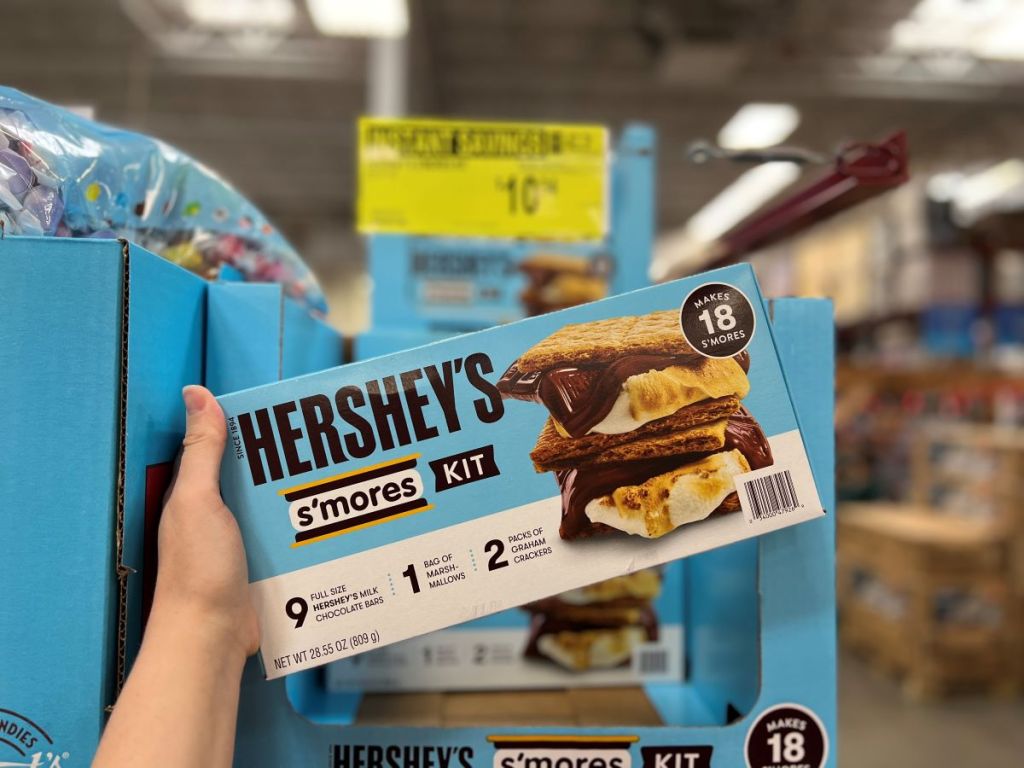 Hand holding a Hershey s'mores kit by the display at Sam's Club