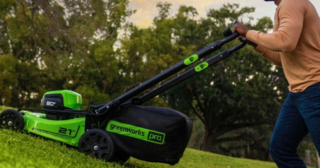 Man with a Greenworks self-propelled electric Greenworks lawnmower