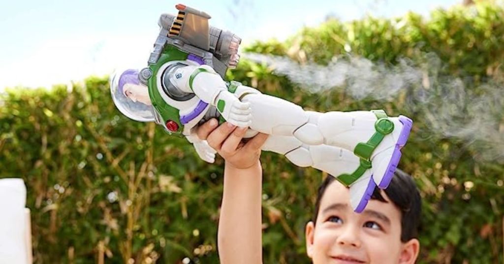 Little boy playing with and flying a Buzz Lightyear action figure