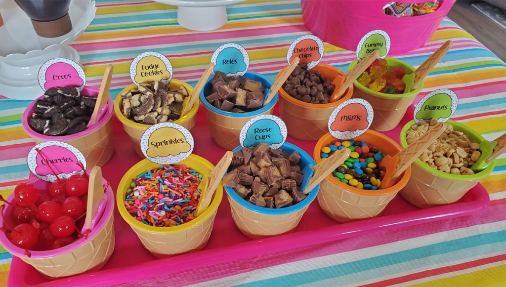 ice cream toppings on tray in ice cream themed cups