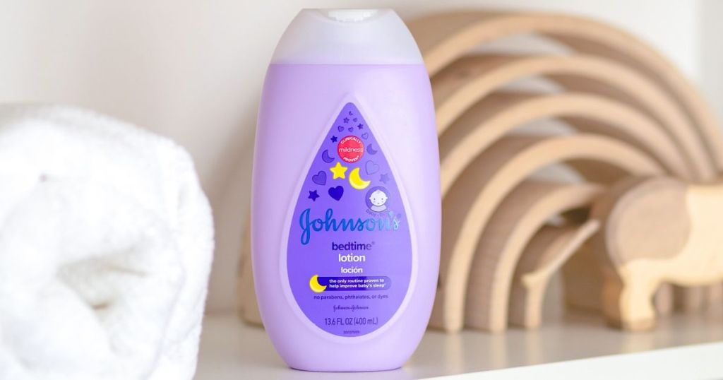 Johnson Baby Bedtime Lotion on a shelf next to a towel and a wooden baby puzzle