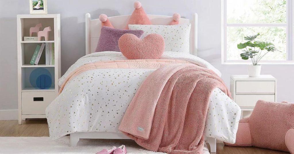 A child's room with white and pink comforter