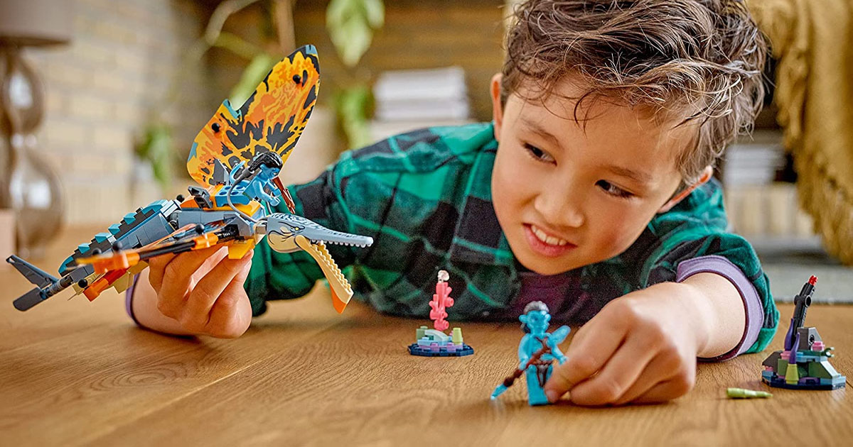 boy playing with lego avatar lego set