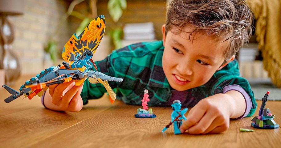 boy playing with lego avatar lego set