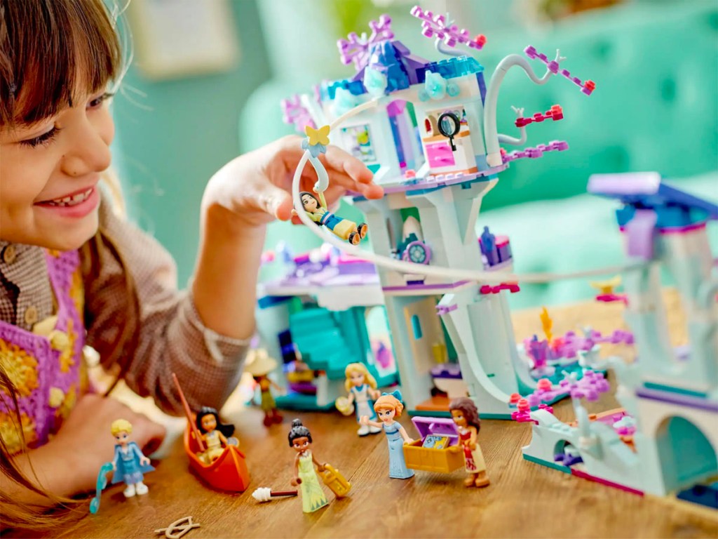فتاة تلعب بمجموعة بيت الشجرة المسحور من LEGO